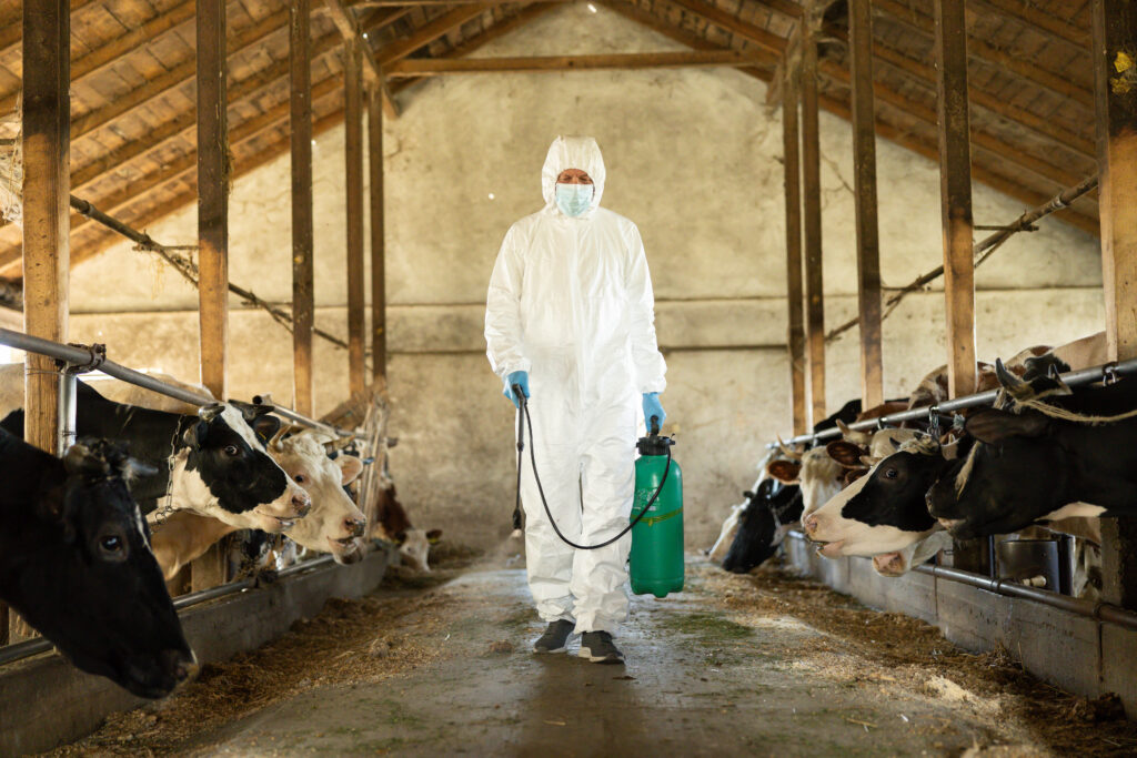 hombre con uniforme aplicando desinfectante para animales